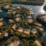Aerial view of lush tropical resort houses surrounded by water in Playa del Carmen, Mexico.